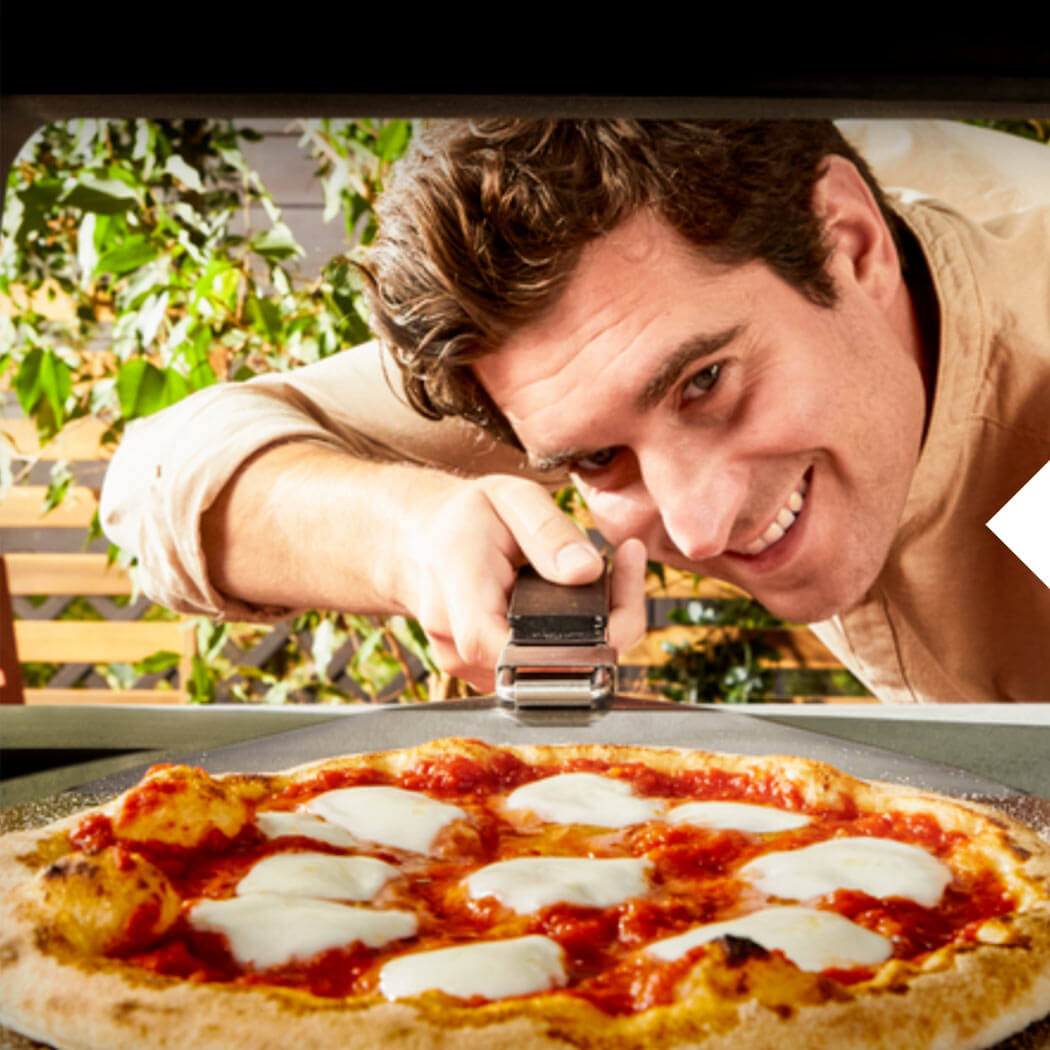 Pizza-Rezepte EM Mann holt die Pizza aus dem Pizzaofen